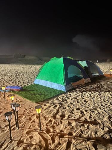 HunaywahDubai Tourism and Travel Services的沙滩上的帐篷和灯光