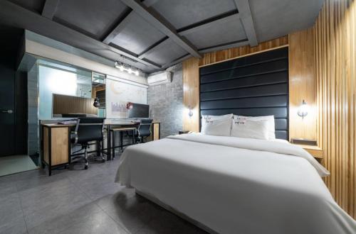 仁川市Hotel Trip的卧室配有一张白色大床和一张书桌