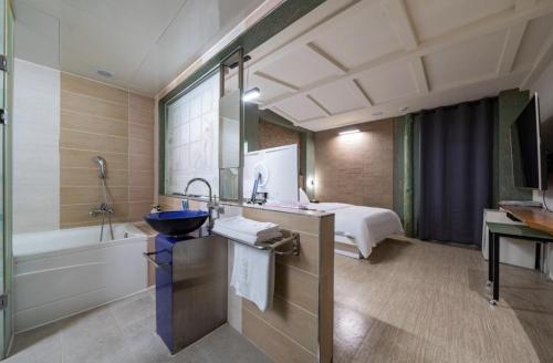 仁川市Hotel Trip的一间带水槽的浴室和一张位于客房内的床