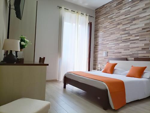 伊格莱西亚斯Domos La Corte Ghibellina的一间卧室设有一张大床和砖墙