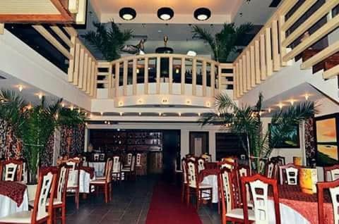 迪夫亚卡Different Hotel & Restaurant的餐厅内带红色椅子和桌子的用餐室