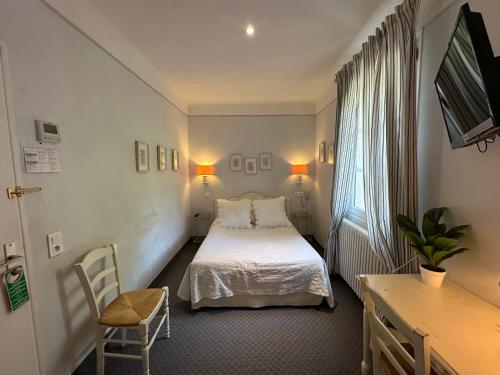 坎松瑞雷巴黎圣母院酒店的配有一张床、一张书桌和一扇窗户的酒店客房