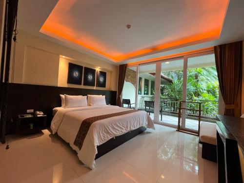 芭东海滩R-Mar Resort and Spa - SHA Plus的一间带大床的卧室和一个阳台
