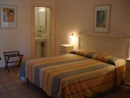 伊索拉迪卡波里祖托Borghetto Beach Club Resort的一间卧室配有一张床,浴室设有水槽