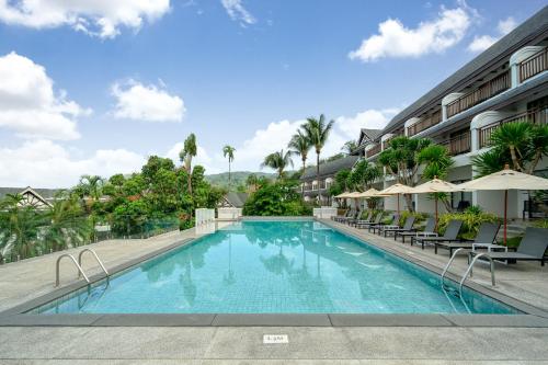 芭东海滩Andamantra Resort and Villa Phuket - SHA Extra Plus的游泳池,带椅子和遮阳伞