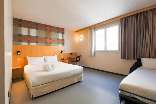 尼斯easyHotel Nice Palais des Congrès – Old Town的酒店客房配有两张床和一张书桌