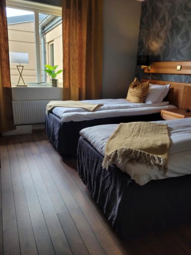维纳什堡Arena Hotell的酒店客房设有两张床和窗户。