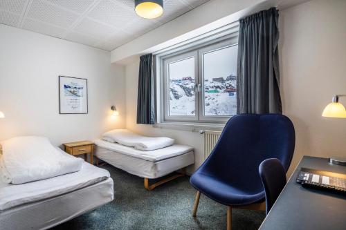 西西缪特HOTEL SØMA Sisimiut的客房设有床、椅子和窗户。