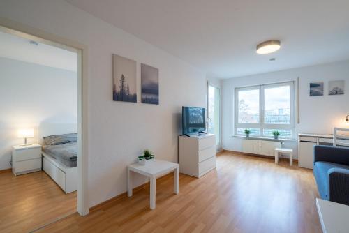 菲尔斯滕瓦尔德2 Zimmer mit Balkon, Wohnzimmer mit Arbeitsplatz, zentral, top!的一间卧室配有一张床、一台电视和一面镜子