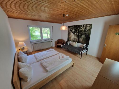 特罗伊赫特林根冒险校园宾馆的一间大卧室,配有一张大床和一张沙发