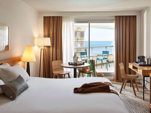 比亚里茨索菲特币艾日兹米拉玛尔塔拉斯酒店的酒店客房设有一张床,享有海景。