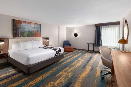 诺克斯维尔诺克斯维尔中心造纸厂拉昆塔套房酒店的配有一张床和一张书桌的酒店客房