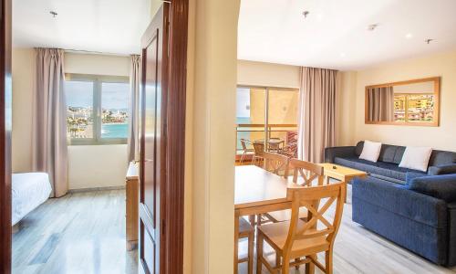 贝纳尔马德纳日落海滩俱乐部公寓酒店的带沙发的客厅和用餐室