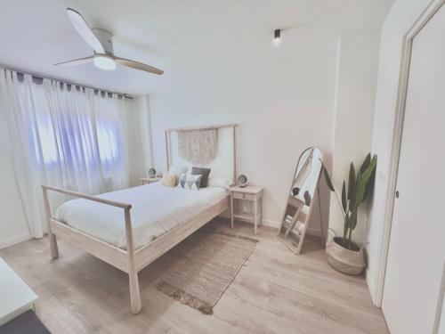 蒙宗Precioso apartamento en Monzón con terraza, PISCINA,parque infantil y PARKING的白色卧室配有床和吊扇