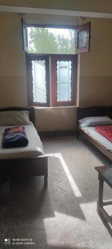 拉瓦尔品第Aurangzeb hotel的客房设有两张床和窗户。
