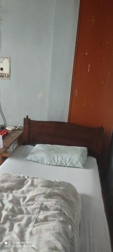 拉瓦尔品第Aurangzeb hotel的卧室里一张未铺好的床,卧室里设有橙色的墙壁