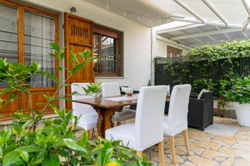 马尔米堡Villino Claudia的庭院配有木桌和白色椅子