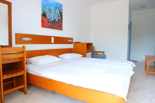 萨索斯达娜厄酒店 的一间卧室配有一张大木床和白色床单