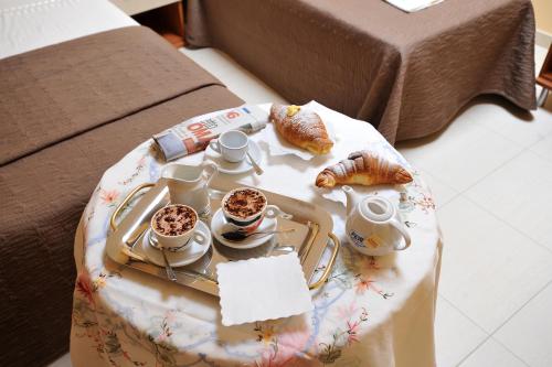 圣乔瓦尼·罗通多卡萨奥格罗住宿加早餐旅馆的桌上的咖啡和羊角面包托盘