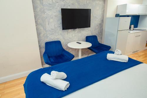 巴统orbi city pearl hotel的一间卧室配有蓝色的床和两张蓝色椅子