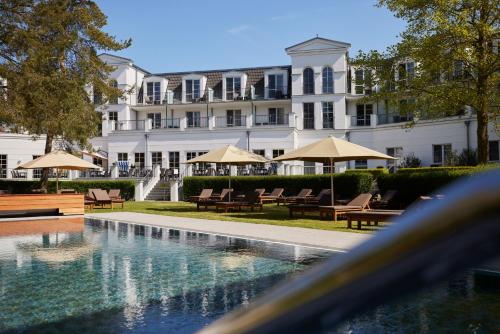 青斯特Strandhotel Zingst的大楼前设有游泳池的酒店