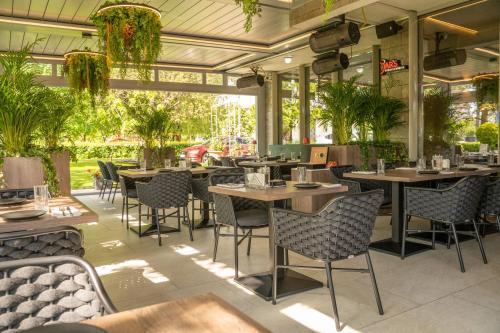 锡比乌摩尔高级酒店的一间设有桌椅的餐厅,种植了植物
