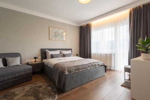 普里什蒂纳Prishtina City Apartments的一间卧室配有一张床和一张沙发