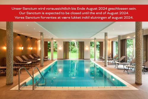 基尔基尔考夫曼罗曼蒂克酒店的酒店游泳池设有桌椅