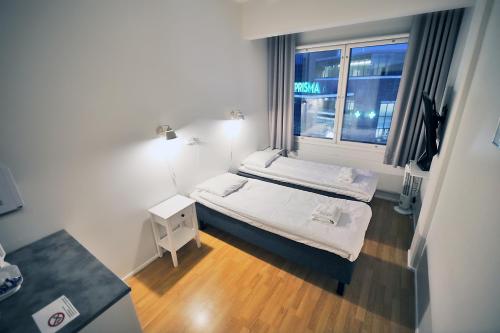 凯拉瓦Hotelli Kerava的小房间设有两张床和窗户