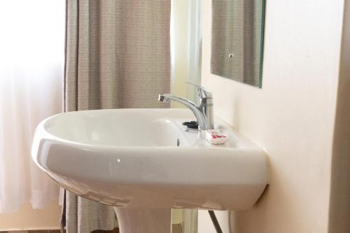 尼耶利Mayas Suites的浴室设有白色水槽和镜子
