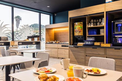 阿雅克修Holiday Inn Express Ajaccio, an IHG Hotel的餐厅设有餐桌,上面放有食物盘