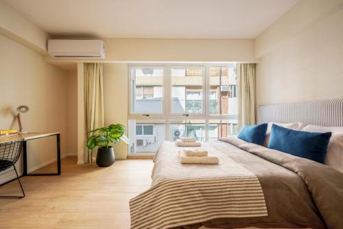 布宜诺斯艾利斯Fliphaus Be Libertador - Lux Loft 12-22的一间卧室配有一张大床和两条毛巾