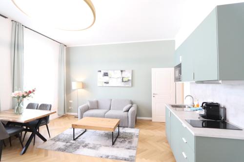 维也纳Vienna Stay Apartments or Rooms 1050的厨房以及带沙发和桌子的客厅。