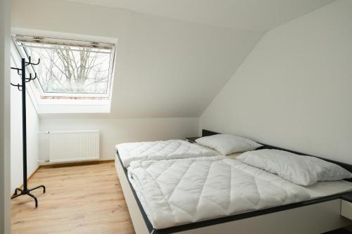 BarnbachBÄRNAppartements 2的窗户客房内的一张白色床