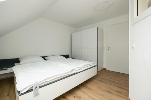 BarnbachBÄRNAppartements 2的白色卧室配有床和书桌