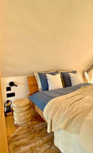 布泽吉Wygórowane - nowoczesne stodoły pod Tatrami的一间卧室配有一张带蓝色和白色枕头的床