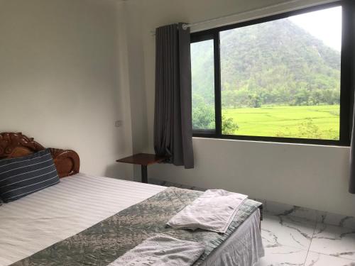 枚州县Mai chau Horizon Homestay的一间卧室设有一张床和一个大窗户
