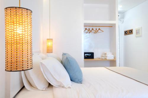 斯卡拉拉扎海滩酒店的卧室配有白色的床和吊灯。