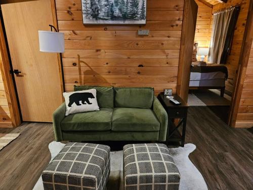 索蒂纳科奇Sylvan Valley Lodge and Cellars的客厅配有绿色沙发和2张搁脚凳