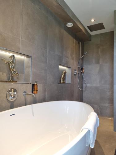 霍斯特霍斯特 - 芬洛公园酒店的带淋浴的浴室配有白色浴缸。