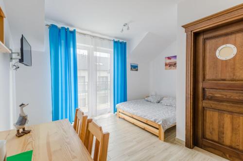 弗瓦迪斯瓦沃沃Willa Artus的一间卧室配有一张床、一张桌子和一个窗户。