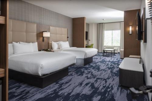莫纳汉斯Fairfield Inn & Suites Monahans的酒店客房配有两张床和一张书桌