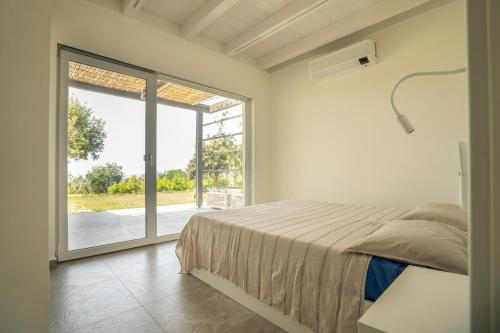 特罗佩阿Alle Preziose Dimore的一间卧室设有一张床和一个大型滑动玻璃门