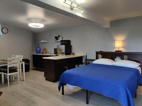 CrosbiesLaBellevue Benjamin's Holiday Rental Home﻿的一间卧室配有蓝色的床和一张书桌,还设有一间厨房