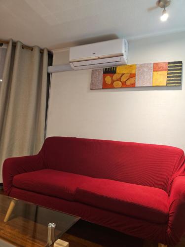 圣地亚哥圣伊格纳西奥套房公寓的客厅里红色的沙发,配有空调