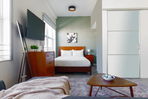 迈阿密海滩Franklin Suites South Beach的一间卧室配有一张床和一台电视。