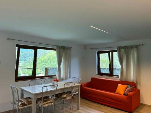莱德罗Apartments in Pieve di Ledro/Ledrosee 22704的客厅配有红色的沙发和桌子