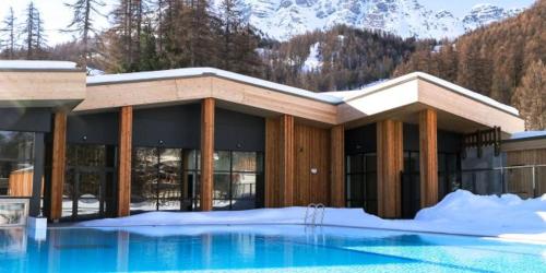 瓦尔Vars, Appart spacieux rénové 4 couchages dans chalet的一座在雪中设有游泳池的建筑