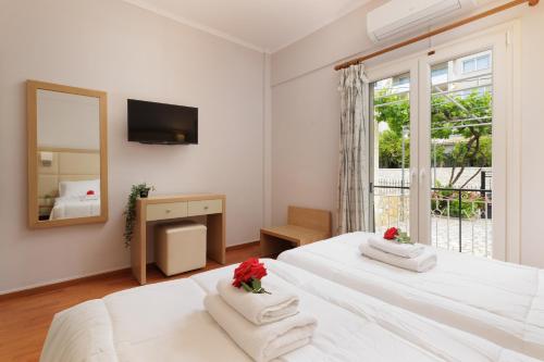 达西亚Santos Luxury Apartments的一间白色卧室,配有两张床和镜子