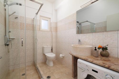 达西亚Santos Luxury Apartments的带淋浴、卫生间和盥洗盆的浴室